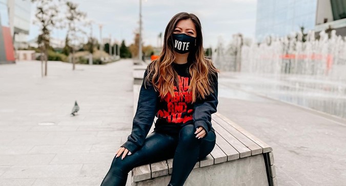 A photo of a woman wearing a mask that says vote.